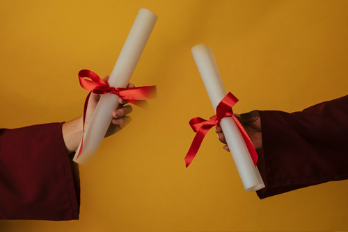 Two hands holding Diplomas